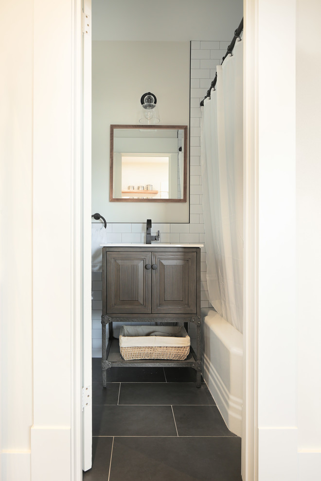 Modelo de cuarto de baño principal actual pequeño con paredes blancas, suelo negro y encimeras blancas