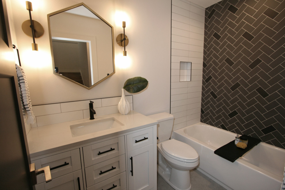 Cette image montre une salle de bain traditionnelle de taille moyenne pour enfant avec un placard à porte shaker, des portes de placard blanches, une baignoire en alcôve, WC séparés, un carrelage noir et blanc, des carreaux de porcelaine, un mur blanc, un sol en carrelage de porcelaine, un lavabo encastré, un plan de toilette en quartz modifié, un sol gris, un plan de toilette blanc, meuble simple vasque et meuble-lavabo sur pied.