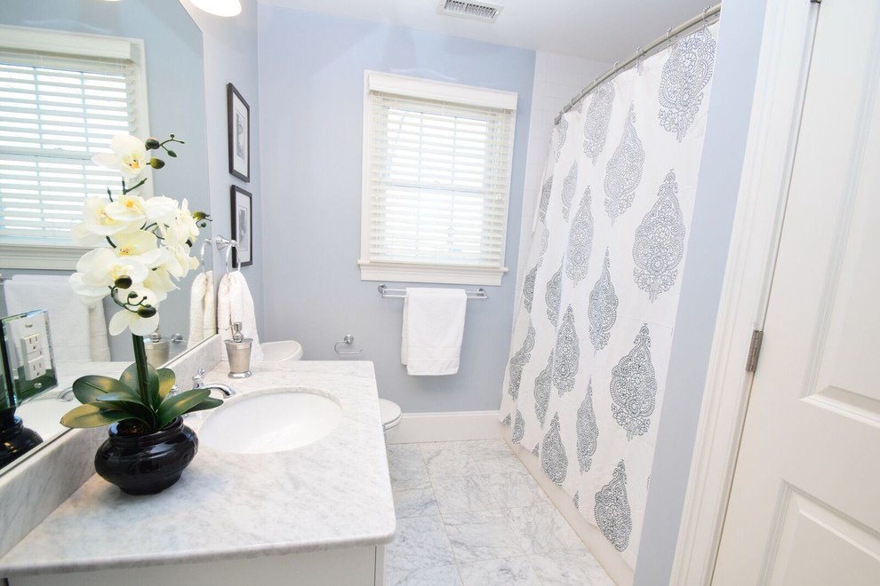 Пример оригинального дизайна: ванная комната среднего размера в стиле неоклассика (современная классика) с фасадами в стиле шейкер, белыми фасадами, ванной в нише, душем в нише, раздельным унитазом, белой плиткой, керамической плиткой, синими стенами, мраморным полом, душевой кабиной, накладной раковиной, мраморной столешницей, белым полом и шторкой для ванной
