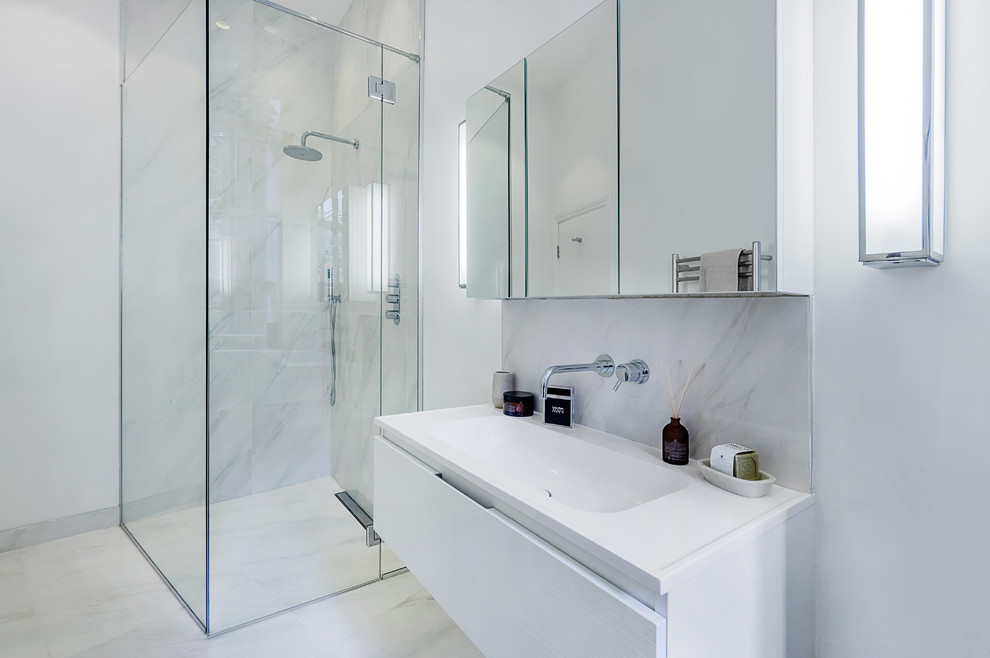 Photo of a medium sized contemporary ensuite bathroom in London with a console sink, a corner shower, a wall mounted toilet, white tiles, porcelain tiles, white walls and porcelain flooring.