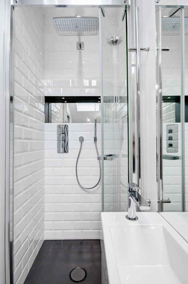 Inspiration for a small contemporary ensuite bathroom in London with a built-in shower, a one-piece toilet, white tiles, ceramic tiles, white walls, a trough sink, glass worktops, grey floors and a sliding door.
