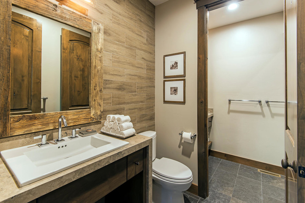 Diseño de cuarto de baño rural con lavabo encastrado, armarios con paneles lisos, puertas de armario de madera en tonos medios, baldosas y/o azulejos marrones, paredes beige y encimeras beige