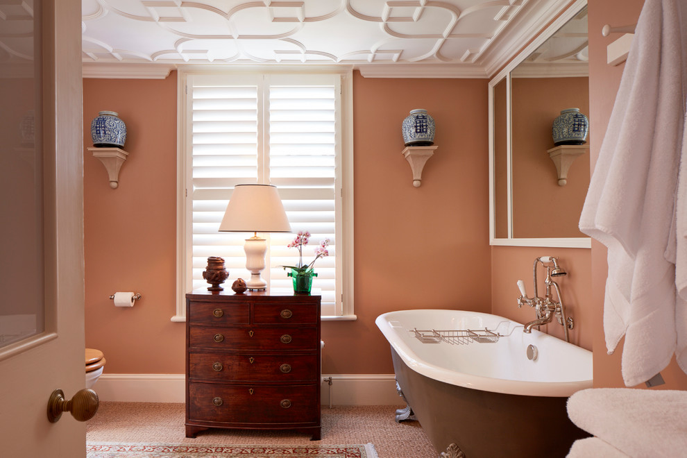 Exemple d'une salle de bain asiatique en bois foncé avec une baignoire sur pieds, un combiné douche/baignoire, un mur beige et un placard à porte plane.
