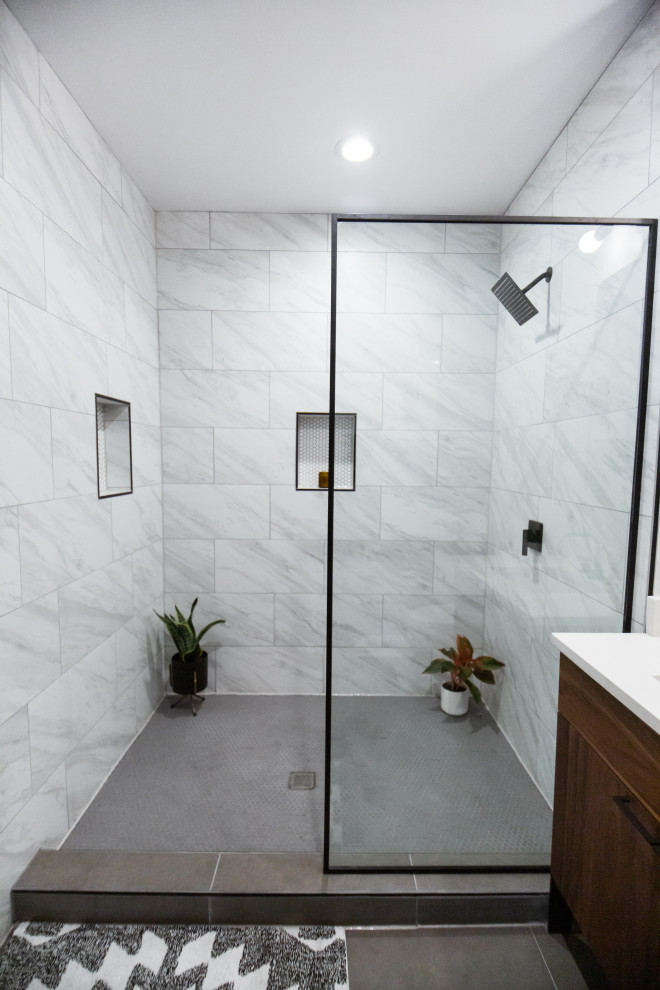 Photo of a medium sized modern ensuite bathroom in Denver with freestanding cabinets, medium wood cabinets, a walk-in shower, a one-piece toilet, white tiles, ceramic tiles, grey walls, ceramic flooring, a submerged sink, engineered stone worktops, grey floors, an open shower and white worktops.