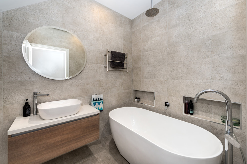 Medium sized contemporary shower room bathroom in Melbourne with flat-panel cabinets, brown cabinets, a walk-in shower, a one-piece toilet, grey tiles, grey walls, a vessel sink, grey floors, an open shower and white worktops.