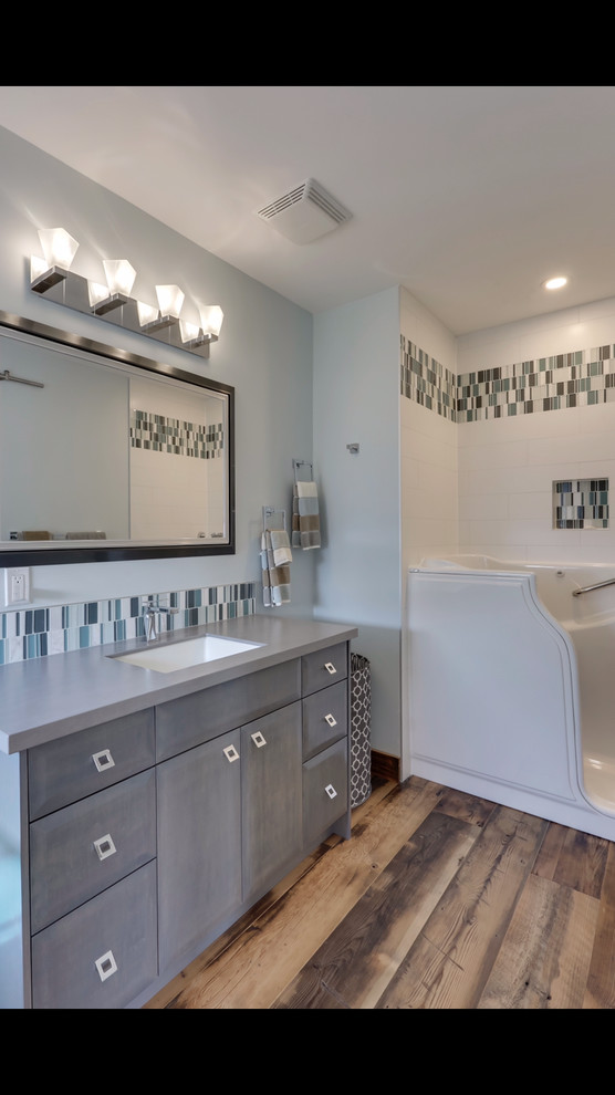 Inspiration for a mid-sized mid-century modern master blue tile and glass sheet light wood floor and brown floor freestanding bathtub remodel in Calgary with flat-panel cabinets, gray cabinets, gray walls, an undermount sink, wood countertops and gray countertops