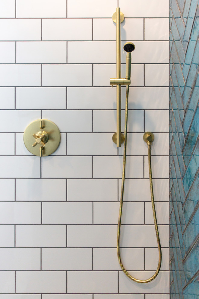 Example of a mid-sized 1950s white tile and subway tile concrete floor and gray floor alcove shower design in New York with flat-panel cabinets, medium tone wood cabinets, a two-piece toilet, white walls, an undermount sink, quartzite countertops, a hinged shower door and white countertops