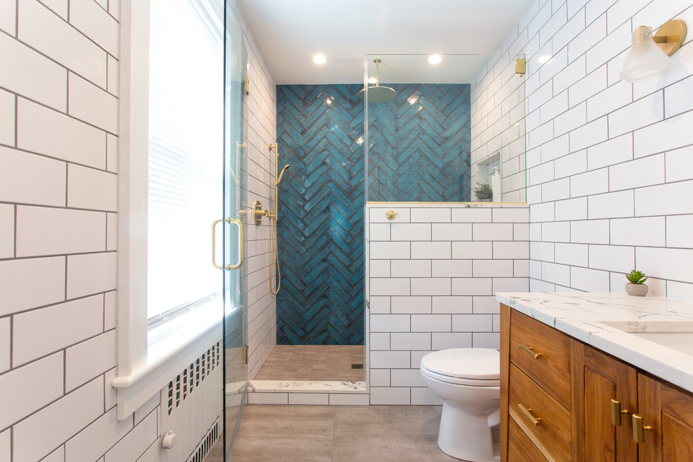 Design ideas for a medium sized retro bathroom in New York with flat-panel cabinets, medium wood cabinets, an alcove shower, a two-piece toilet, white tiles, metro tiles, white walls, concrete flooring, a submerged sink, quartz worktops, grey floors, a hinged door and white worktops.
