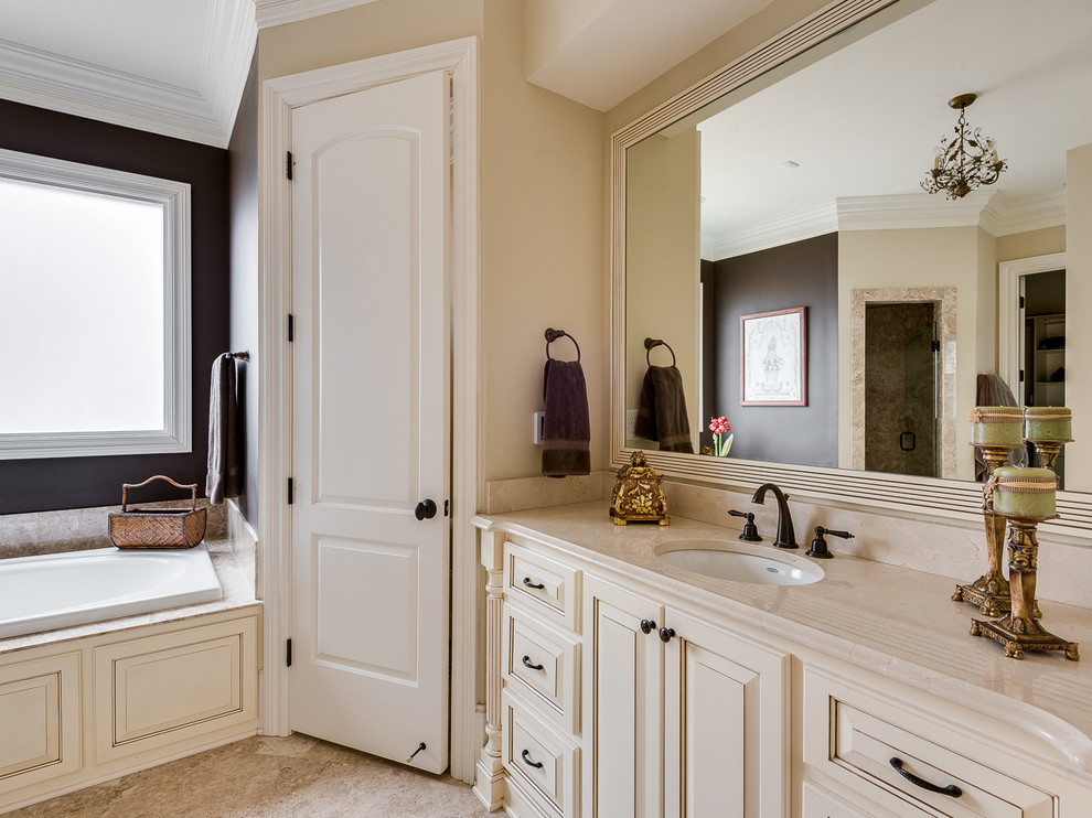 Exempel på ett stort klassiskt en-suite badrum, med ett undermonterad handfat, luckor med upphöjd panel, vita skåp, marmorbänkskiva, ett platsbyggt badkar, en hörndusch, en toalettstol med hel cisternkåpa, beige kakel, porslinskakel, beige väggar och klinkergolv i porslin
