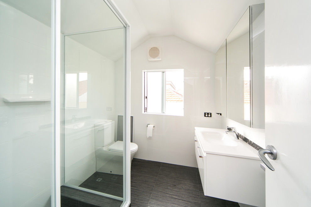 Immagine di una piccola stanza da bagno per bambini moderna con ante lisce, ante bianche, doccia ad angolo, WC monopezzo, piastrelle bianche, piastrelle in ceramica e pavimento con piastrelle in ceramica