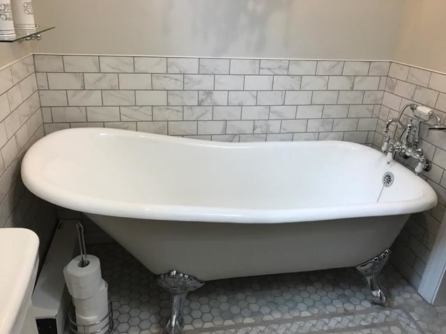 Klassisk inredning av ett mellanstort badrum, med ett badkar med tassar, en dusch i en alkov, en toalettstol med separat cisternkåpa, grå kakel, porslinskakel, grå väggar, mosaikgolv och ett konsol handfat