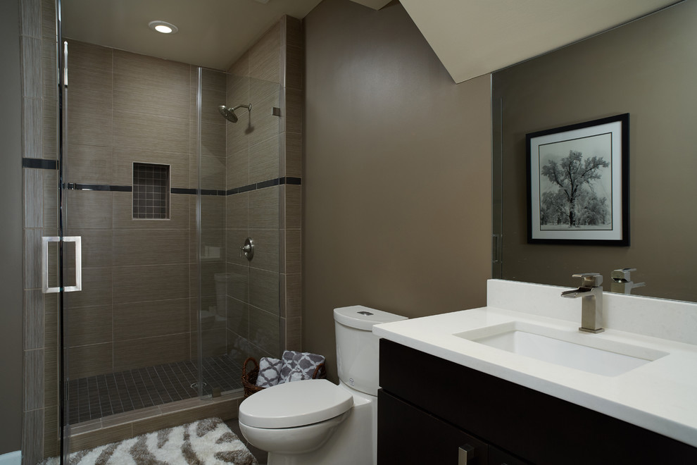 Inspiration for a medium sized contemporary ensuite bathroom in DC Metro with flat-panel cabinets, dark wood cabinets, a freestanding bath, beige tiles, pebble tiles, beige walls, light hardwood flooring, a submerged sink and engineered stone worktops.