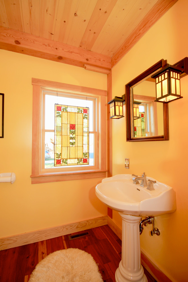 Bild på ett mellanstort lantligt badrum, med gula väggar och mellanmörkt trägolv