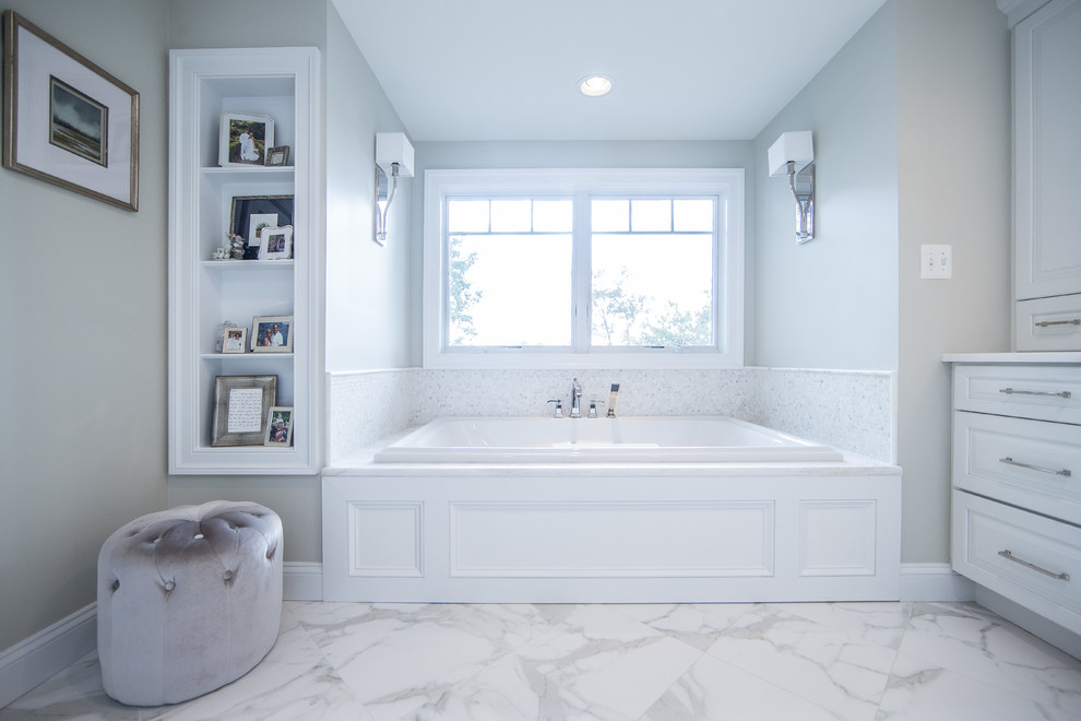 Inspiration for a large rustic master white tile and stone tile marble floor and white floor drop-in bathtub remodel in DC Metro with raised-panel cabinets, white cabinets, gray walls, an undermount sink, marble countertops and white countertops