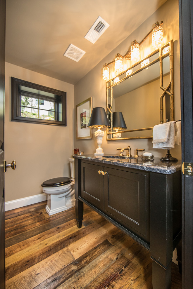 Rustik inredning av ett mellanstort grå grått badrum med dusch, med skåp i shakerstil, svarta skåp, en toalettstol med separat cisternkåpa, beige väggar, mellanmörkt trägolv, ett undermonterad handfat, granitbänkskiva och brunt golv