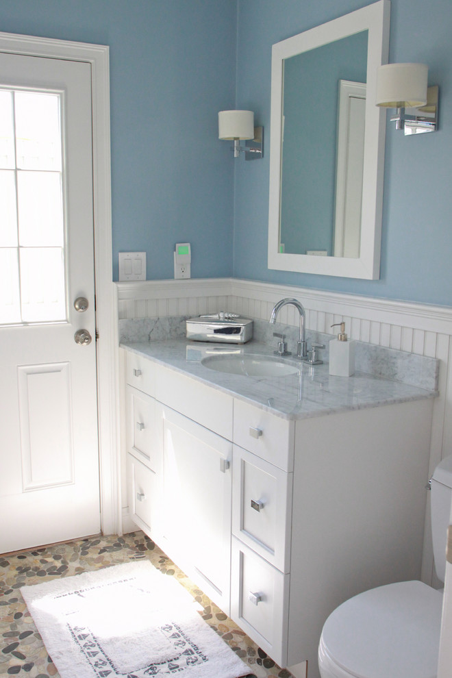 Exempel på ett litet maritimt badrum med dusch, med skåp i shakerstil, vita skåp, en toalettstol med separat cisternkåpa, kakel i småsten, blå väggar, klinkergolv i småsten, ett undermonterad handfat och marmorbänkskiva