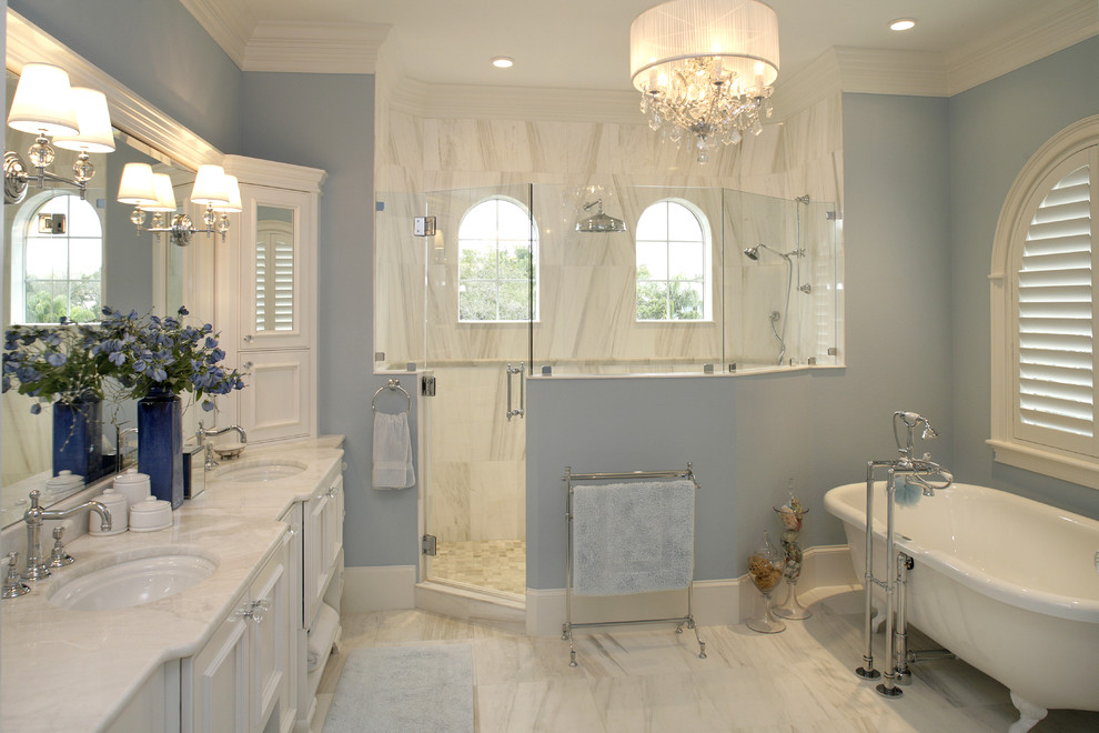 Imagen de cuarto de baño clásico con bañera con patas, encimera de mármol y baldosas y/o azulejos de mármol