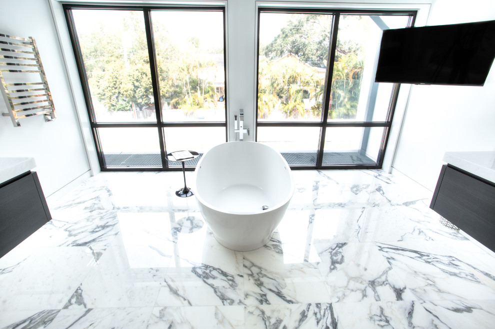 Imagen de cuarto de baño principal clásico renovado con puertas de armario grises, bañera exenta y paredes blancas