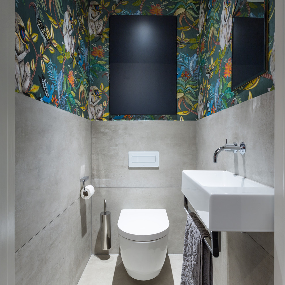Immagine di un piccolo bagno di servizio minimal con WC sospeso, piastrelle grigie, piastrelle in gres porcellanato, pareti multicolore, pavimento in gres porcellanato, lavabo sospeso e pavimento grigio