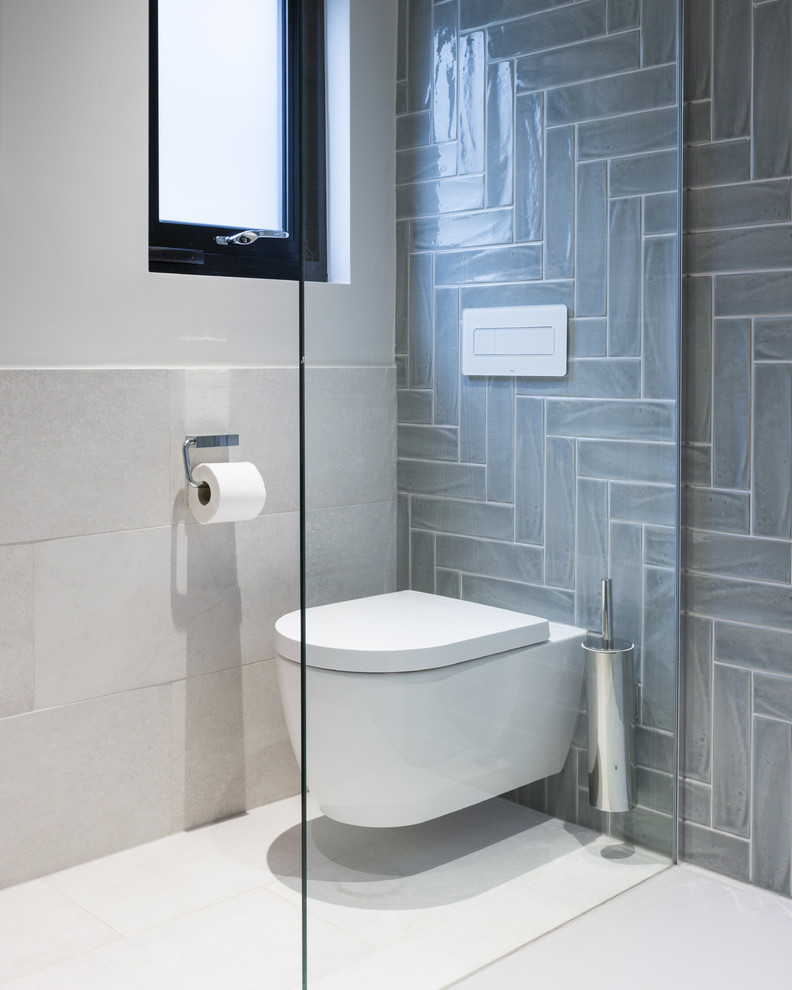 Idées déco pour une petite salle de bain principale contemporaine avec un placard en trompe-l'oeil, une douche ouverte, WC suspendus, un carrelage gris, des carreaux de porcelaine, un mur blanc, un sol en carrelage de porcelaine, un lavabo intégré, un sol gris, aucune cabine, des portes de placard grises, un plan de toilette en surface solide et un plan de toilette blanc.