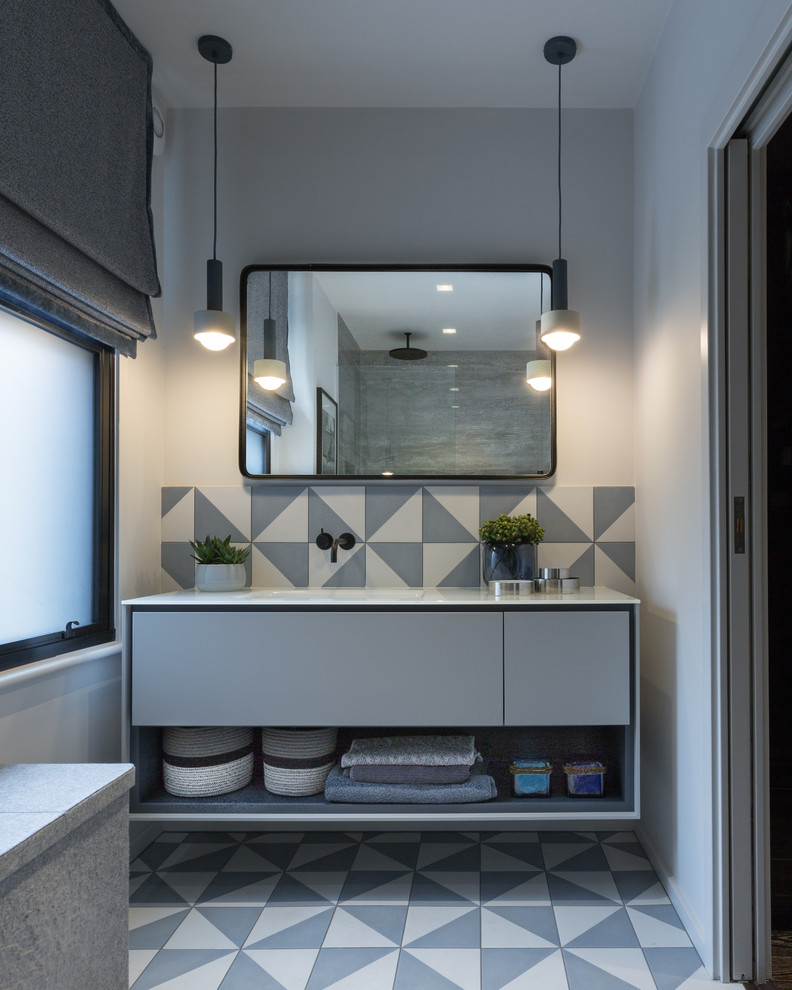 Idéer för ett mellanstort modernt vit en-suite badrum, med möbel-liknande, en öppen dusch, en vägghängd toalettstol, grå kakel, porslinskakel, vita väggar, klinkergolv i porslin, ett integrerad handfat, laminatbänkskiva, blått golv, med dusch som är öppen och grå skåp
