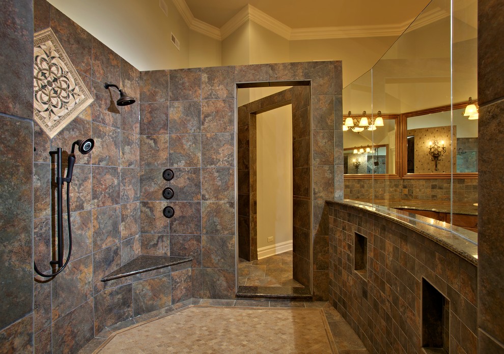 Inredning av ett klassiskt mycket stort en-suite badrum, med en öppen dusch, luckor med upphöjd panel, skåp i mellenmörkt trä, ett platsbyggt badkar, brun kakel, grå kakel, beige väggar, skiffergolv, ett fristående handfat, granitbänkskiva, med dusch som är öppen, skifferkakel och brunt golv