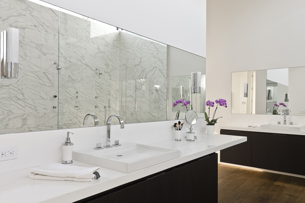Ejemplo de cuarto de baño moderno con lavabo sobreencimera, armarios con paneles lisos, puertas de armario negras y encimeras blancas
