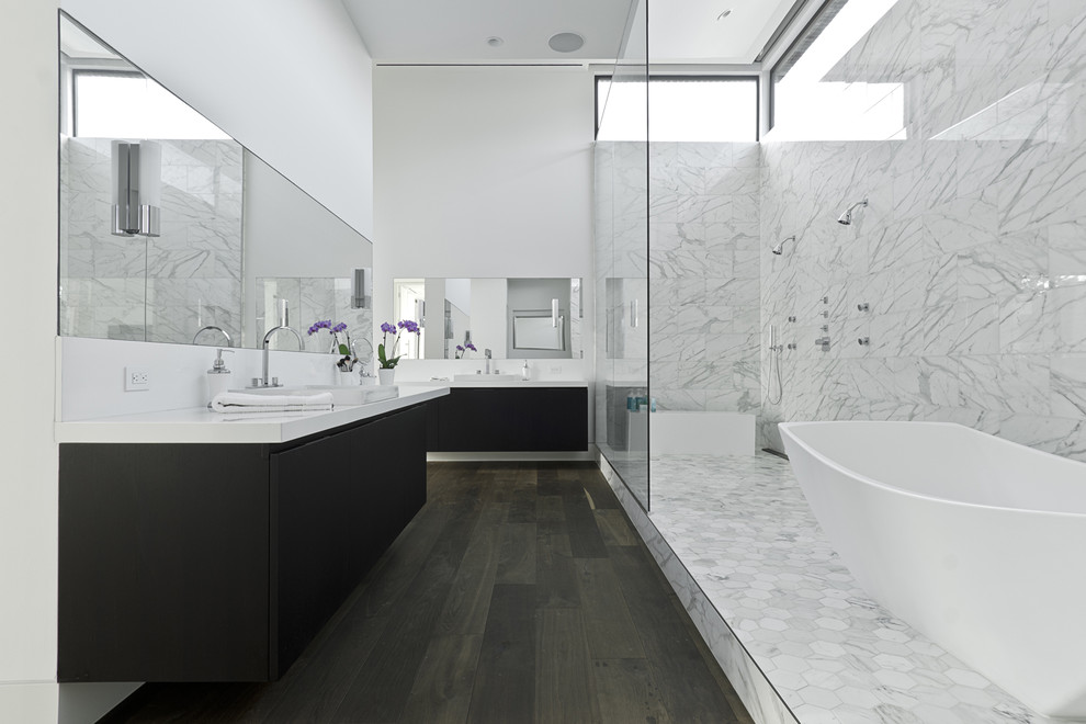 Ispirazione per una stanza da bagno design con lavabo da incasso, ante lisce, ante nere, vasca freestanding, doccia doppia e piastrelle bianche