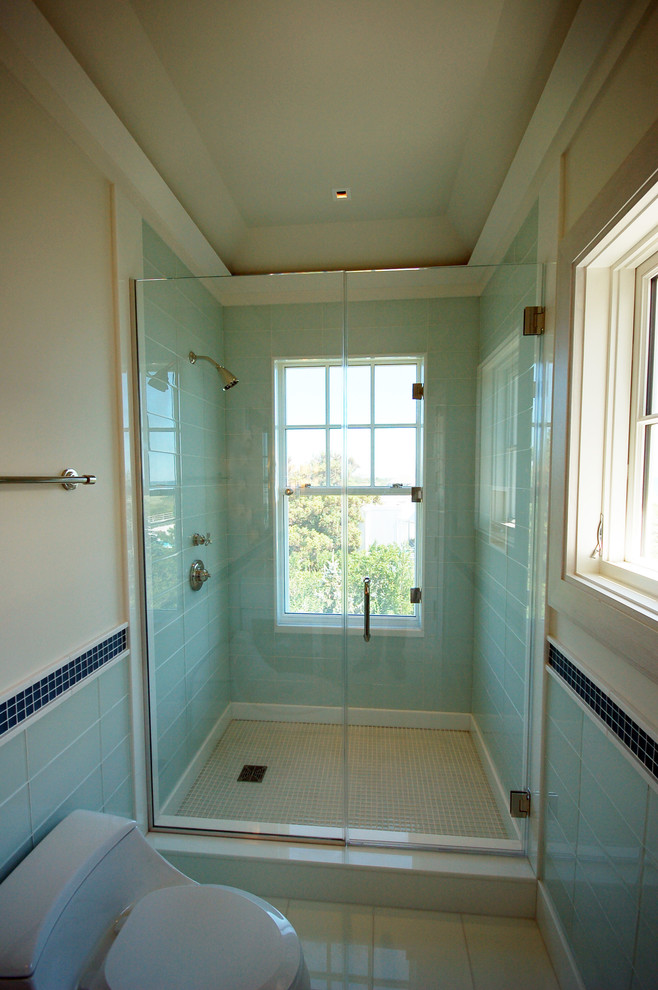 This is an example of a large contemporary ensuite bathroom in New York with an alcove shower, a one-piece toilet, blue tiles, glass tiles, beige walls, porcelain flooring, beige floors and a hinged door.