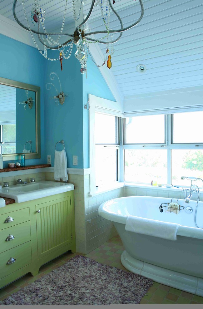 Esempio di una stanza da bagno padronale boho chic di medie dimensioni con ante a filo, ante verdi, vasca freestanding, WC monopezzo, pareti blu, pavimento con piastrelle a mosaico, lavabo integrato e top in superficie solida
