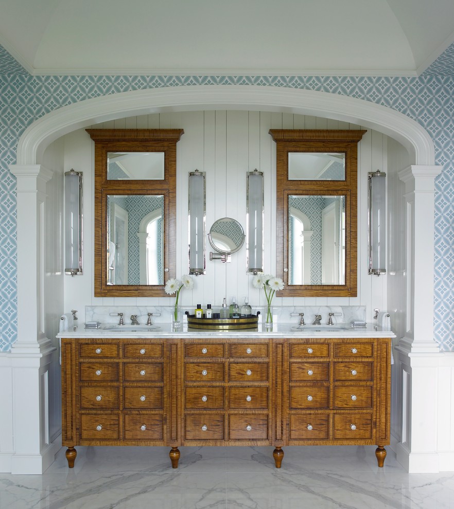 Imagen de cuarto de baño principal costero con puertas de armario de madera oscura, paredes multicolor, suelo de mármol y armarios con paneles empotrados
