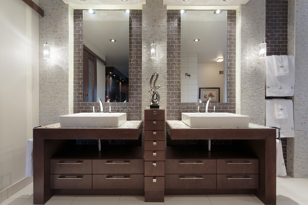 Bild på ett funkis badrum, med ett fristående handfat, släta luckor, skåp i mörkt trä, marmorbänkskiva, ett fristående badkar, en dubbeldusch, en toalettstol med separat cisternkåpa, beige kakel, mosaik och beiget golv