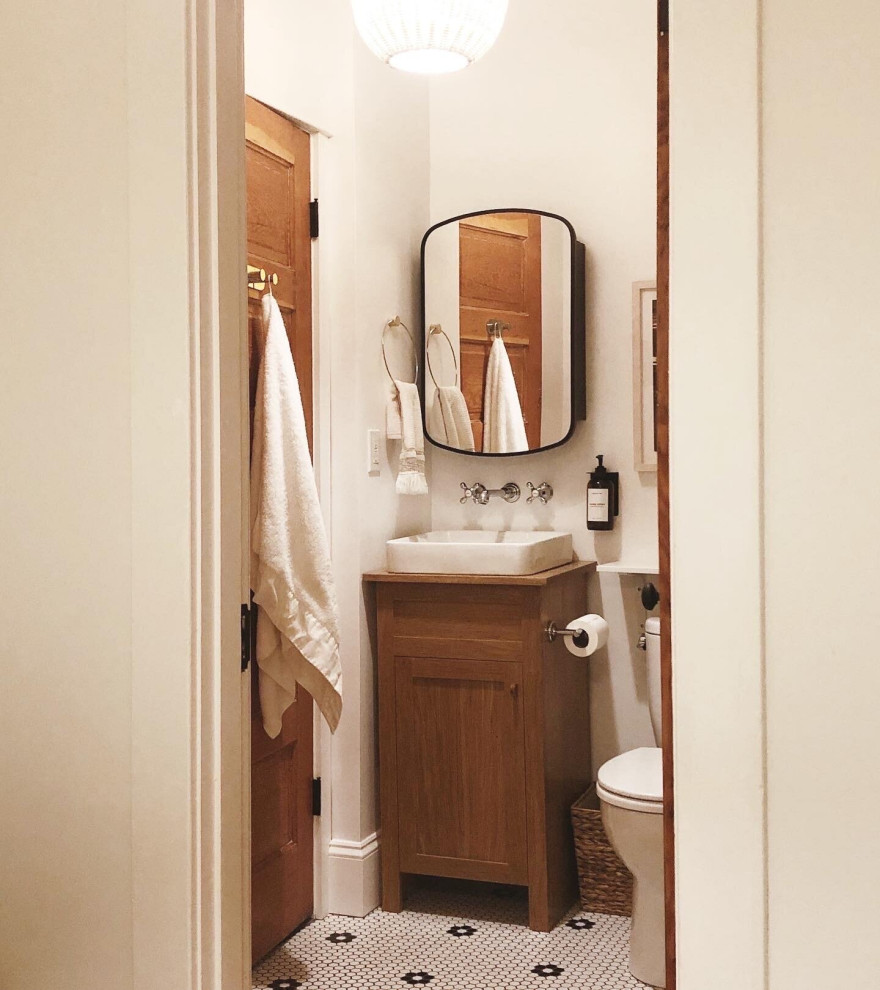 Small bohemian bathroom in Portland with shaker cabinets, brown cabinets, a claw-foot bath, a shower/bath combination, a one-piece toilet, white tiles, ceramic tiles, white walls, mosaic tile flooring, a vessel sink, wooden worktops, white floors, a shower curtain, a wall niche, a single sink and a freestanding vanity unit.