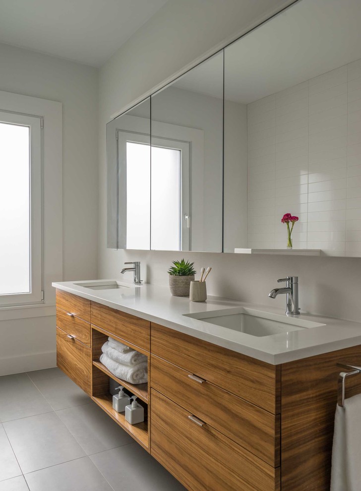 Cette photo montre une salle de bain principale moderne en bois brun de taille moyenne avec un placard à porte plane, un carrelage blanc, un lavabo encastré, un plan de toilette en quartz modifié et un plan de toilette blanc.