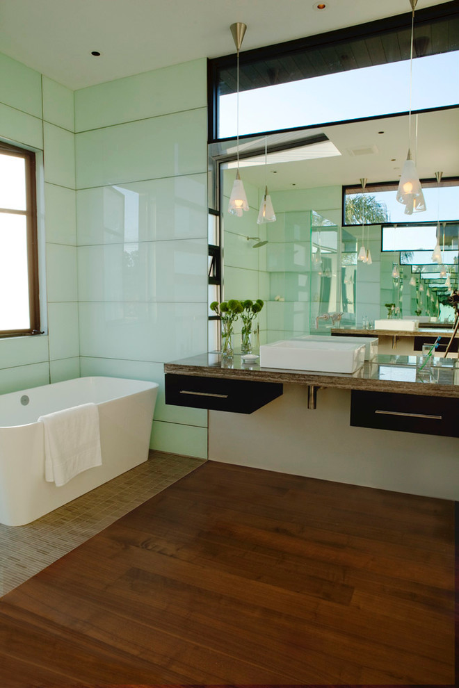 ロサンゼルスにあるコンテンポラリースタイルのおしゃれな浴室 (ベッセル式洗面器、置き型浴槽、緑のタイル、ガラス板タイル、無垢フローリング) の写真