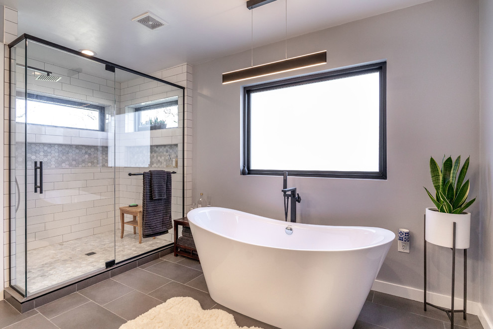 Inspiration for a medium sized contemporary ensuite bathroom in Other with flat-panel cabinets, dark wood cabinets, a freestanding bath, a corner shower, a one-piece toilet, white tiles, metro tiles, grey walls, ceramic flooring, a submerged sink, engineered stone worktops, grey floors, a hinged door and white worktops.