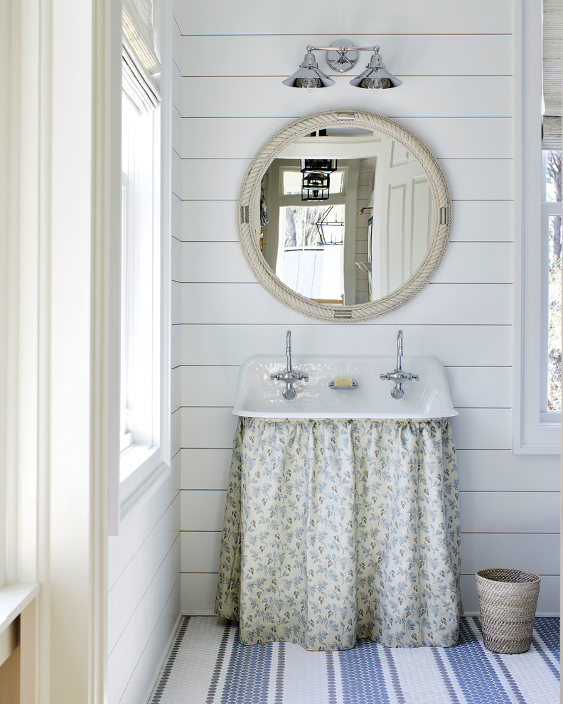 Diseño de cuarto de baño costero con paredes blancas, suelo con mosaicos de baldosas, lavabo de seno grande y suelo multicolor