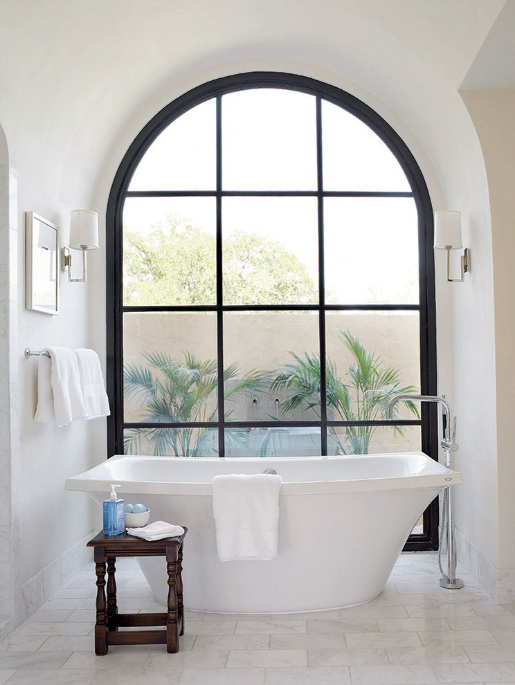 Diseño de cuarto de baño principal mediterráneo con bañera exenta, paredes blancas y ventanas