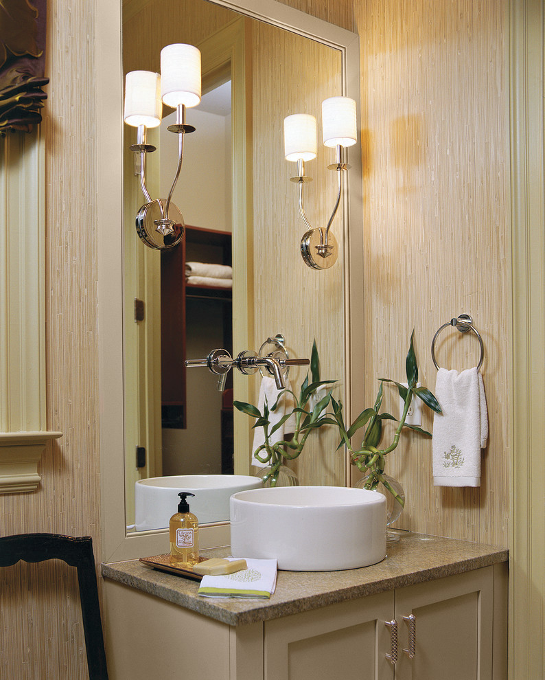 Klassisk inredning av ett badrum, med granitbänkskiva, ett fristående handfat och beige väggar