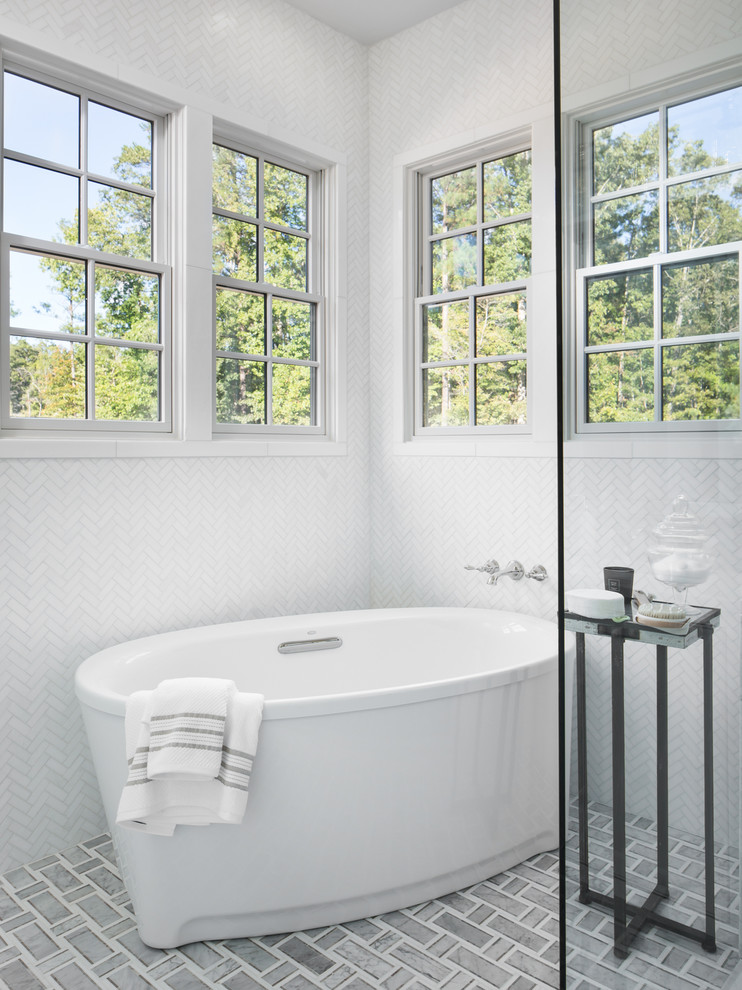 На фото: ванная комната в морском стиле с отдельно стоящей ванной, душевой комнатой, белой плиткой, мраморной плиткой и душем с распашными дверями с