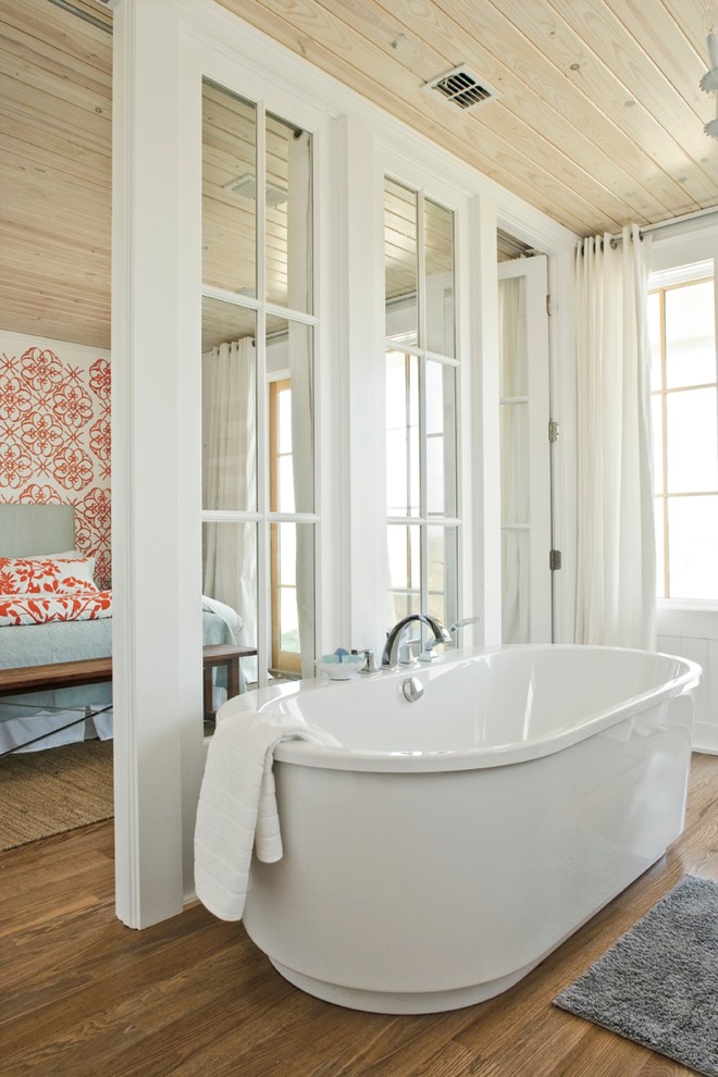 На фото: главная ванная комната в морском стиле с отдельно стоящей ванной, белыми стенами и паркетным полом среднего тона