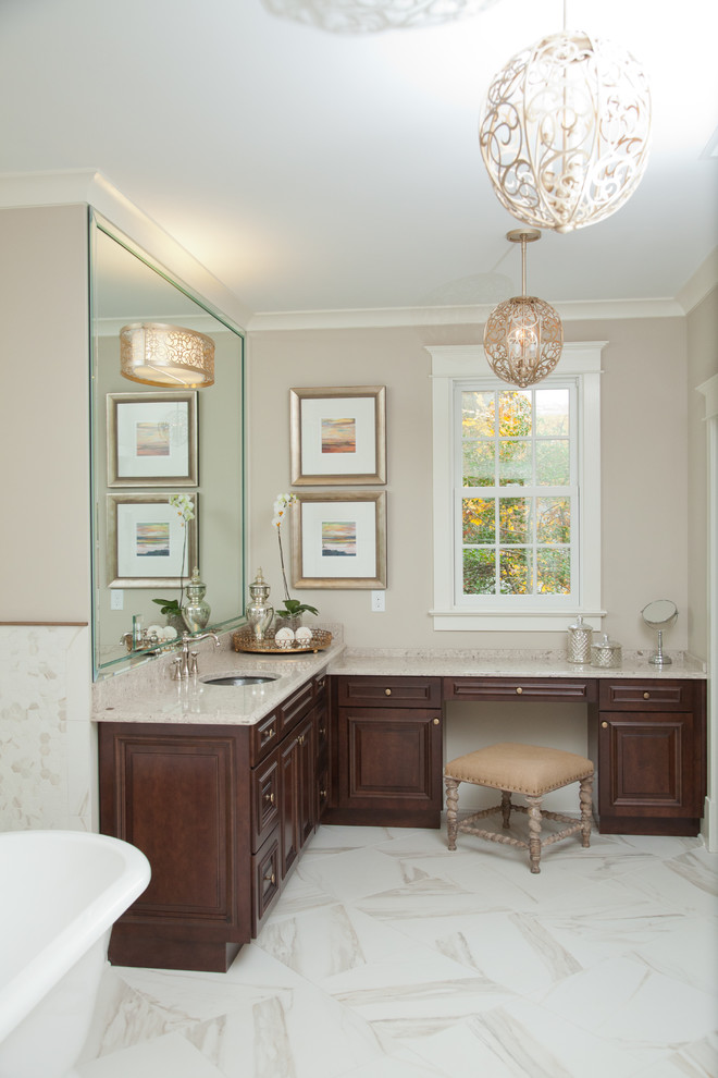 Foto de cuarto de baño clásico con lavabo bajoencimera, armarios con paneles con relieve, puertas de armario de madera en tonos medios y paredes beige