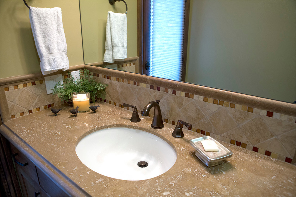 Example of a mid-sized southwest 3/4 beige tile and porcelain tile porcelain tile corner shower design in San Diego with an undermount sink, shaker cabinets, medium tone wood cabinets, limestone countertops, a two-piece toilet and green walls