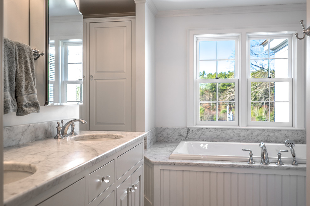 Bathroom - mid-sized cottage master multicolored tile and porcelain tile porcelain tile bathroom idea in Portland Maine with flat-panel cabinets, white cabinets, marble countertops, a one-piece toilet and white walls