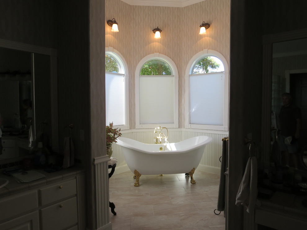Inredning av ett klassiskt mellanstort badrum, med ett badkar med tassar och porslinskakel