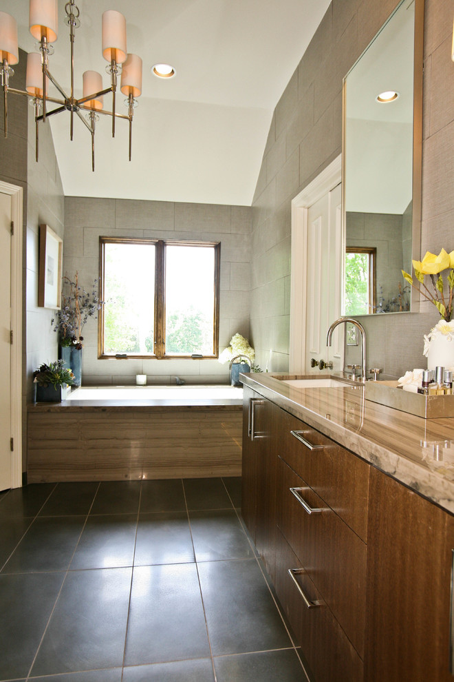 На фото: ванная комната в стиле модернизм с ванной в нише, угловым душем, керамогранитной плиткой, бежевыми стенами, полом из керамогранита, врезной раковиной и столешницей из известняка
