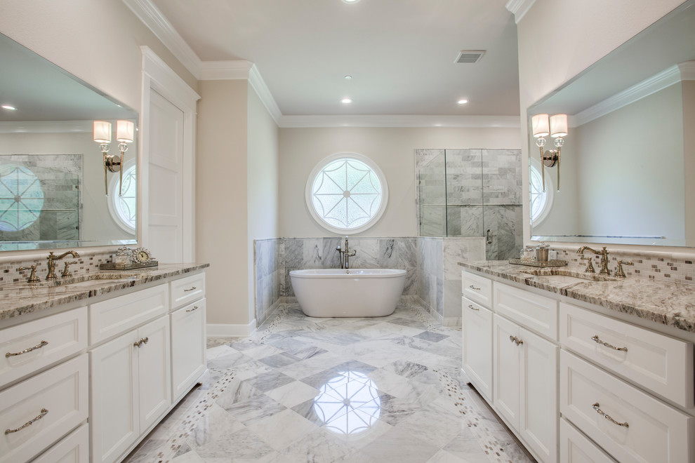 Inspiration for a large transitional master gray tile, white tile and marble tile marble floor and green floor bathroom remodel in Dallas with recessed-panel cabinets, white cabinets, beige walls, an undermount sink, granite countertops, a hinged shower door and brown countertops