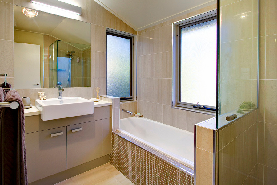 Bild på ett stort funkis badrum, med släta luckor, beige skåp, ett platsbyggt badkar, en hörndusch, beige kakel, beige väggar, ett fristående handfat, beiget golv och dusch med gångjärnsdörr