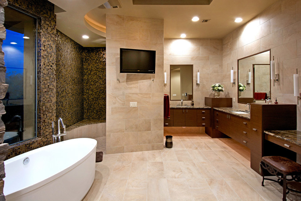 Photo of an ensuite bathroom in Phoenix with a submerged sink, flat-panel cabinets, dark wood cabinets, granite worktops, a freestanding bath, an alcove shower, beige tiles, stone tiles, beige walls and limestone flooring.
