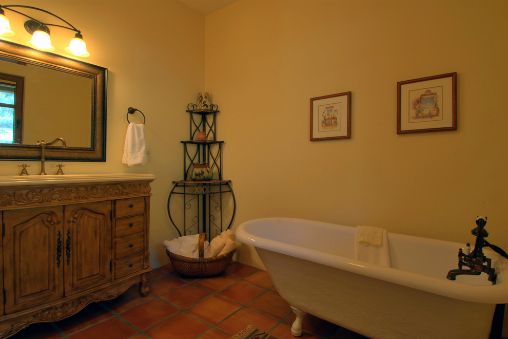バンクーバーにある中くらいなサンタフェスタイルのおしゃれな浴室 (家具調キャビネット、中間色木目調キャビネット、猫足バスタブ、黄色い壁、アンダーカウンター洗面器) の写真
